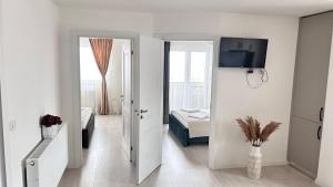 a white room with a room with a bed and a television at DURU luxury property in Rădăuţi