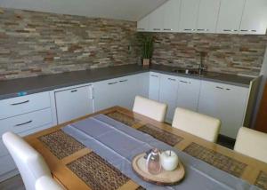 a kitchen with a table and white cabinets at Schönes Ferienhaus mit Pool in Biograd na Moru
