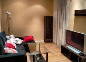 sala de estar con sofá y TV de pantalla plana en Leon Apartamento Centro, en León