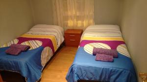 dos camas sentadas una al lado de la otra en una habitación en Leon Apartamento Centro, en León
