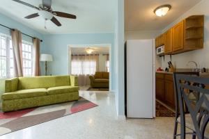 a living room with a green couch and a kitchen at Tangerine Sunsets Murcott in Nassau
