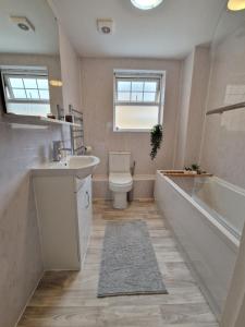 a bathroom with a tub and a toilet and a sink at Apartment Near Wembley Stadium Heathrow London Barnet Luton Airport Hendon Middlesex University - FREE Parking & WiFi - Work Contractors & Tourists Welcome in Edgware