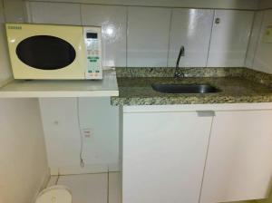 a kitchen with a sink and a microwave at Golden Dolphin Express com roupa de cama e banho gratuito in Caldas Novas +28 photos