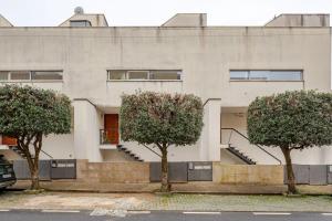 a building with three trees in front of it at Algae n'areia in Moledo