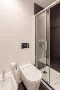 a white bathroom with a toilet and a shower at Algae n'areia in Moledo +15 photos