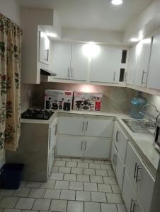 Una cocina con gabinetes blancos y un horno de estufa. en Departamento el REPOSO, en Guadalajara