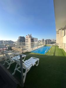 a balcony with two lounge chairs and a swimming pool at La mejor terraza en el centro de Viña del Mar, cerca de todo in Viña del Mar