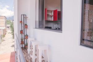 eine Reihe weißer Hocker auf einem Balkon in der Unterkunft Charm & Confort - Tarapoto - Peru in Tarapoto