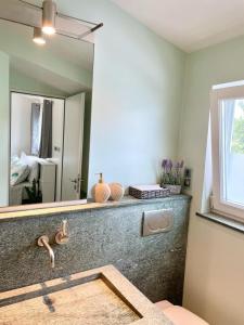 ナッソーにあるTangerine Sunsets Milanの洗面台と大きな鏡のあるバスルーム