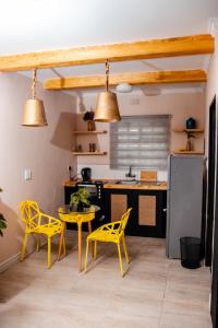 a kitchen with yellow chairs and a table at Kanana Villas-Maun Luxury Studio Suite in Maun
