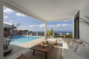a living room with a white couch and a pool at Villa Blanca in Case-Pilote