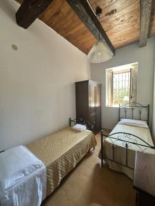 a bedroom with two beds and a window at Agriturismo Tenuta Feraudo in Labonia +28 photos