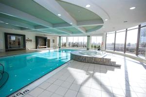 a large swimming pool in a building with windows at Amazing 2BR & 2BTH - Near Square One Mall in Mississauga