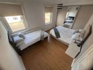 Habitación pequeña con 2 camas y espejo. en Mitchell House, en Bellshill