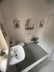 Un baño con lavabo, inodoro y espejo. en Mitchell House, en Bellshill