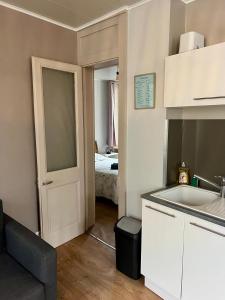 małą kuchnię ze zlewem oraz pokój z łóżkiem w obiekcie Escale en Ville Appart entier T2 centre ville de Cherbourg w mieście Cherbourg en Cotentin
