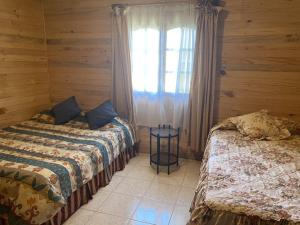 a bedroom with two beds and a window in it at Casa La Vega De Pupuya in Boca Pupuya