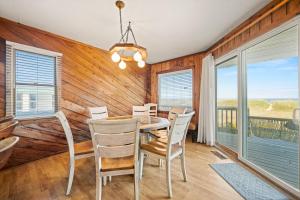 Un comedor con mesa y sillas en Summer Days 4 Bedroom Oceanfront Home, en Kill Devil Hills
