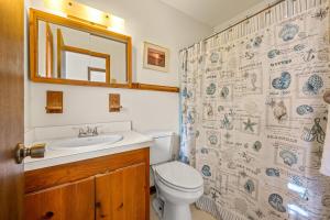 Un baño con inodoro, lavabo y espejo. en Summer Days 4 Bedroom Oceanfront Home, en Kill Devil Hills 33 fotos más