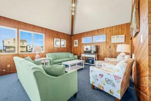 sala de estar con sillas, sofá y TV en Summer Nights 4 Bedroom Oceanside Home, en Kill Devil Hills