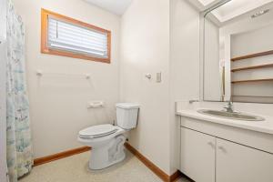 un baño con inodoro y lavabo en Summer Nights 4 Bedroom Oceanside Home, en Kill Devil Hills 29 fotos más