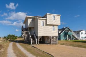 una casa al lado de un camino de tierra en Summer Nights 4 Bedroom Oceanside Home, en Kill Devil Hills