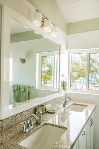 a bathroom with two sinks and a large mirror at Tangerine Sunsets Long Island Santa Maria in Lower Deadmanʼs Cay