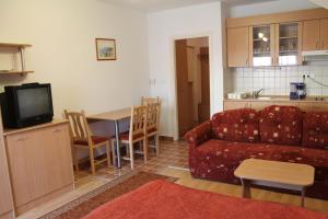 "ハルカーニャ"にあるHarkány-Szt. István Apartmanのリビングルーム(ソファ、テーブル付)、キッチンが備わります。