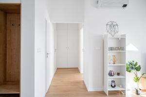 a room with white walls and a hallway with white shelves at City Center Residence Free Parking in Bratislava