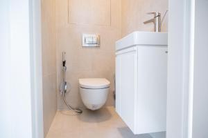 a bathroom with a white toilet and a sink at City Center Residence Free Parking in Bratislava +25 photos
