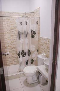 ein Badezimmer mit Toilette und Duschvorhang in der Unterkunft Charm & Confort - Tarapoto - Peru in Tarapoto