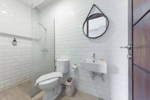 a bathroom with a toilet and a sink and a mirror at Sans Hotel Bobosini Malang by RedDoorz in Malang +36 photos