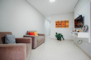 a living room with a couch and a tv at Conforto e tranquilidade in Vitória da Conquista
