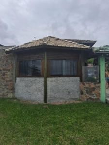 a house with a window on the side of it at Bangalô de frente pro mar in Imbituba