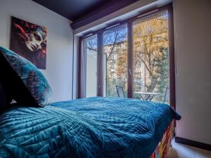 une chambre avec un lit et une grande fenêtre dans l'établissement Loft vistula old town apartament free parking, à Cracovie
