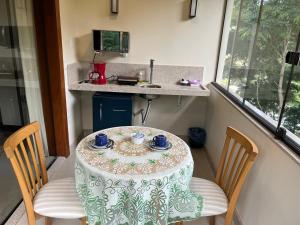 a table with two chairs and a table with cups on it at Aromas da Pedra in Pedra Azul +12 photos