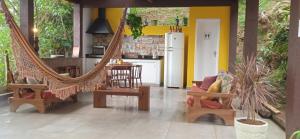 a living room with a hammock and a kitchen at Chalé Duzé Itaipava in Itaipava