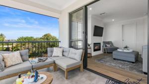 un soggiorno con divano e balcone di Mid Coast Surf & Vines By Wine Coast Holidays a Port Noarlunga South