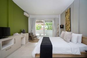 a bedroom with a white bed and a green wall at Villa Stella Seminyak in Seminyak
