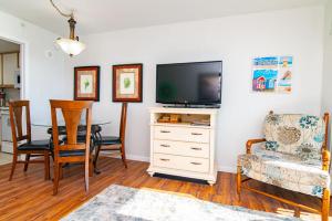 a living room with a television and a table and chairs at Oceanfront TOP LOCATION MODERN RESORT Lazy River Huge Pool Oasis in Myrtle Beach