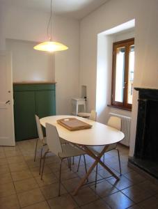 a dining room with a table and chairs and a fireplace at Holiday Home by the Beach in Sala Comacina