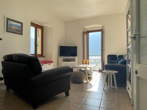 a living room with a couch and a tv at Holiday Home by the Beach in Sala Comacina