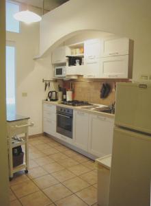 a kitchen with white cabinets and a refrigerator at Holiday Home by the Beach in Sala Comacina +22 photos