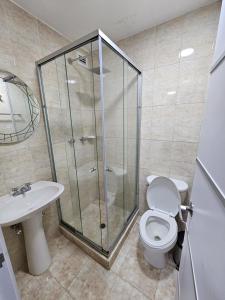 a bathroom with a shower and a toilet and a sink at Lujoso departamento en Playa el Angel in Pampatar +3 photos