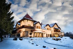 un gran edificio con nieve en el suelo en Hotel Ventus Natural & Medical Spa en Gołdap