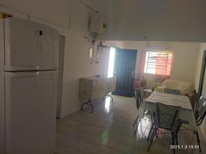 a kitchen with a white refrigerator and a table and chairs at Casa ilusión in Artilleros