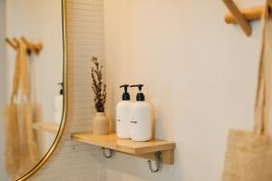 a bathroom with two soap dispensers on a shelf at The Green Room Hotel in Oceanside