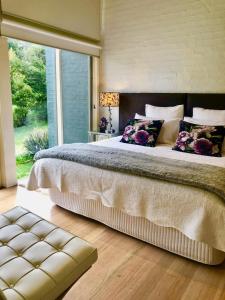 una camera da letto con un letto grande con una grande finestra di Daylesford Lake Villa1 Lake Frontage pet friendly a Daylesford