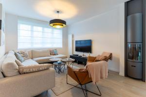 salon z kanapą i telewizorem w obiekcie Superb fully renovated semi-detached house for 6 people w mieście Le Touquet-Paris-Plage