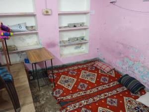 a bedroom with a bed and a table and shelves at Mishra villa in Prayagraj
